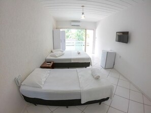 Une chambre d’hôtel avec deux lits, une télévision, un petit réfrigérateur et une fenêtre donnant sur un beau paysage.