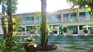 Un edificio moderno con un patio, plantas en macetas y pavimento a cuadros.