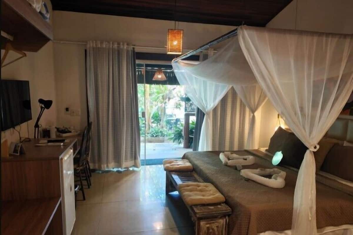 Un dormitorio con cama, escritorio y vistas al exterior.
