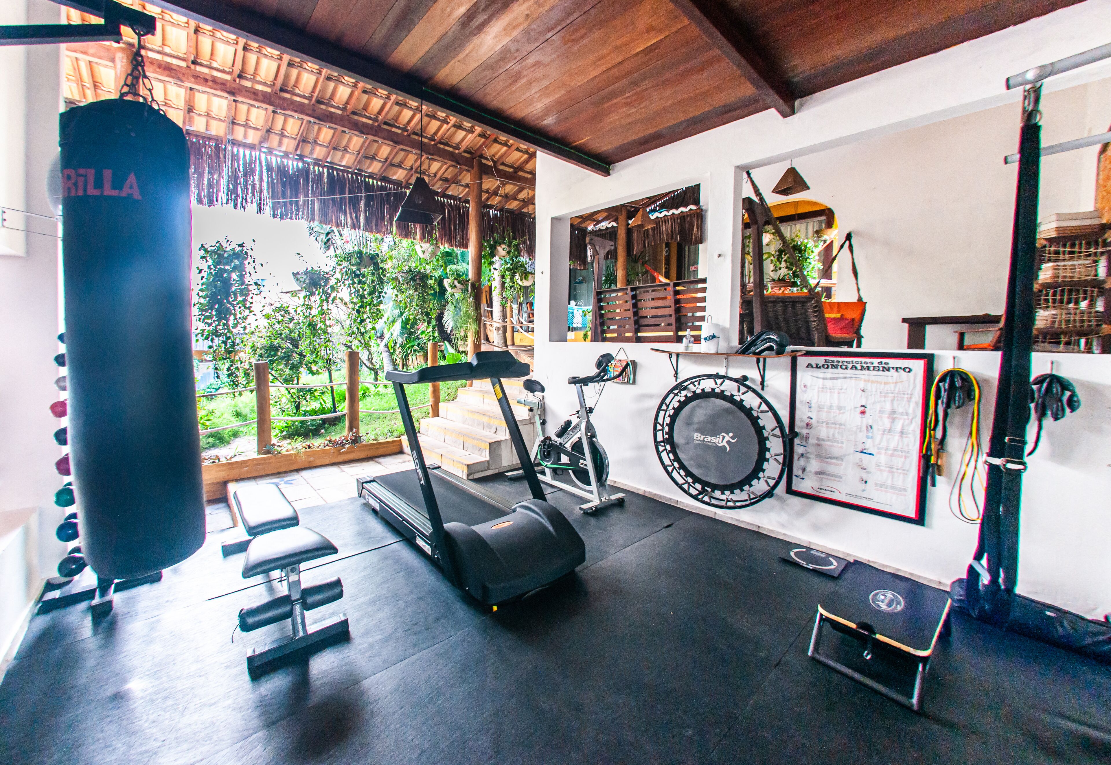 Un gimnasio con un saco de boxeo, cintas de correr y equipo de ejercicio.