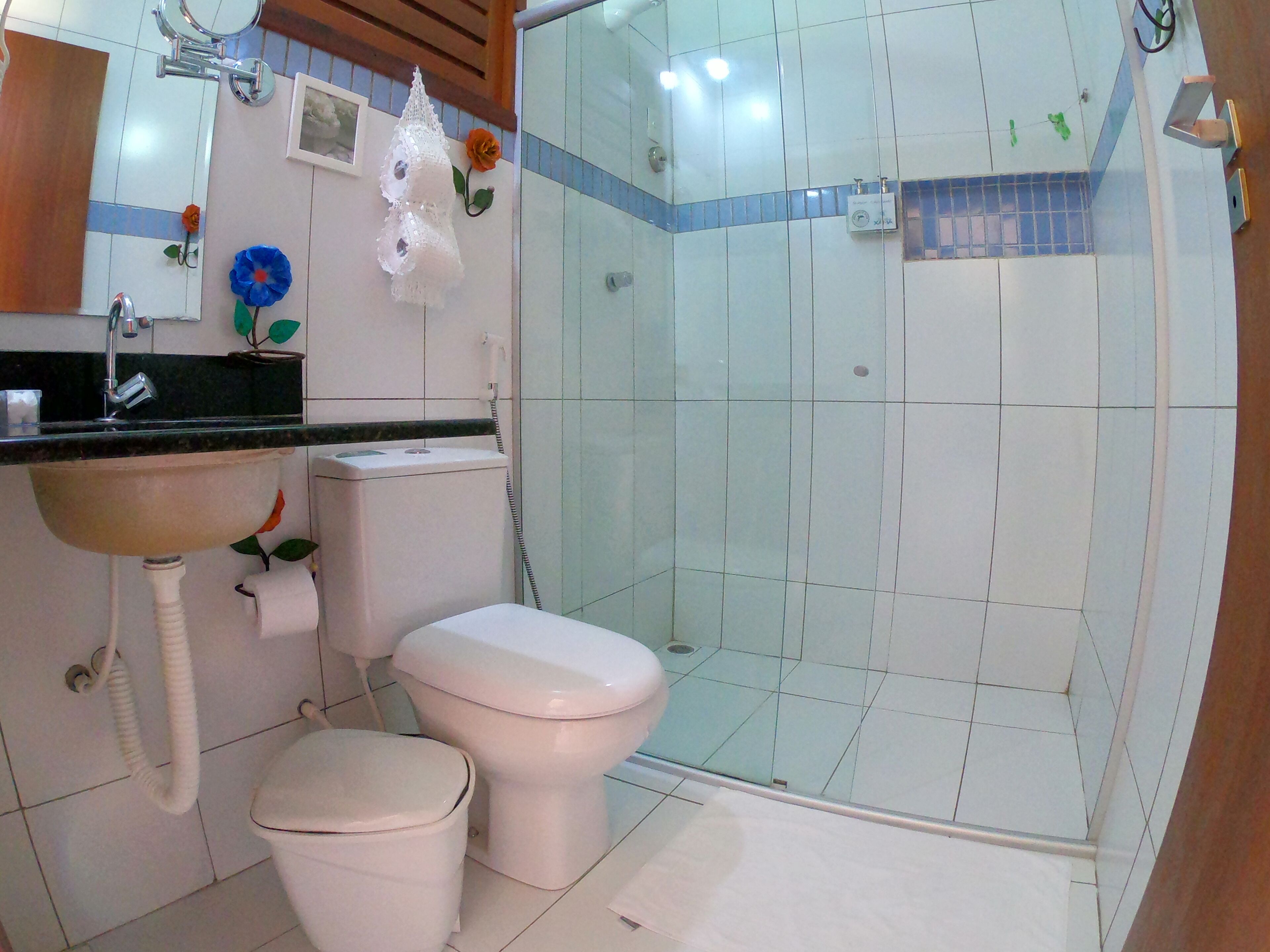 A bathroom with a sink, toilet, and glass-enclosed shower.