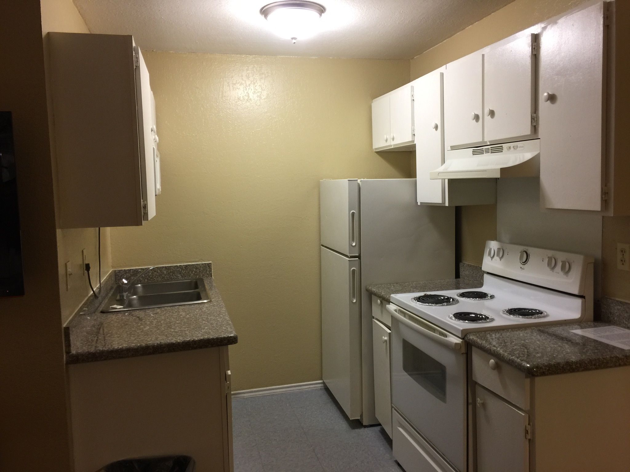 A compact kitchen with a refrigerator, stove, and sink.
