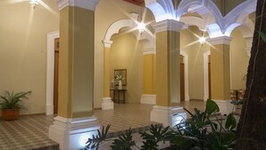A spacious lobby with high ceilings, white columns, and a checkered floor. - Hotel La Casona de Don Jorge (Colima)