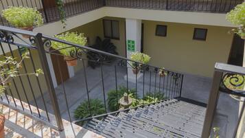 A multi-level outdoor area with a staircase, potted plants, and a metal railing.