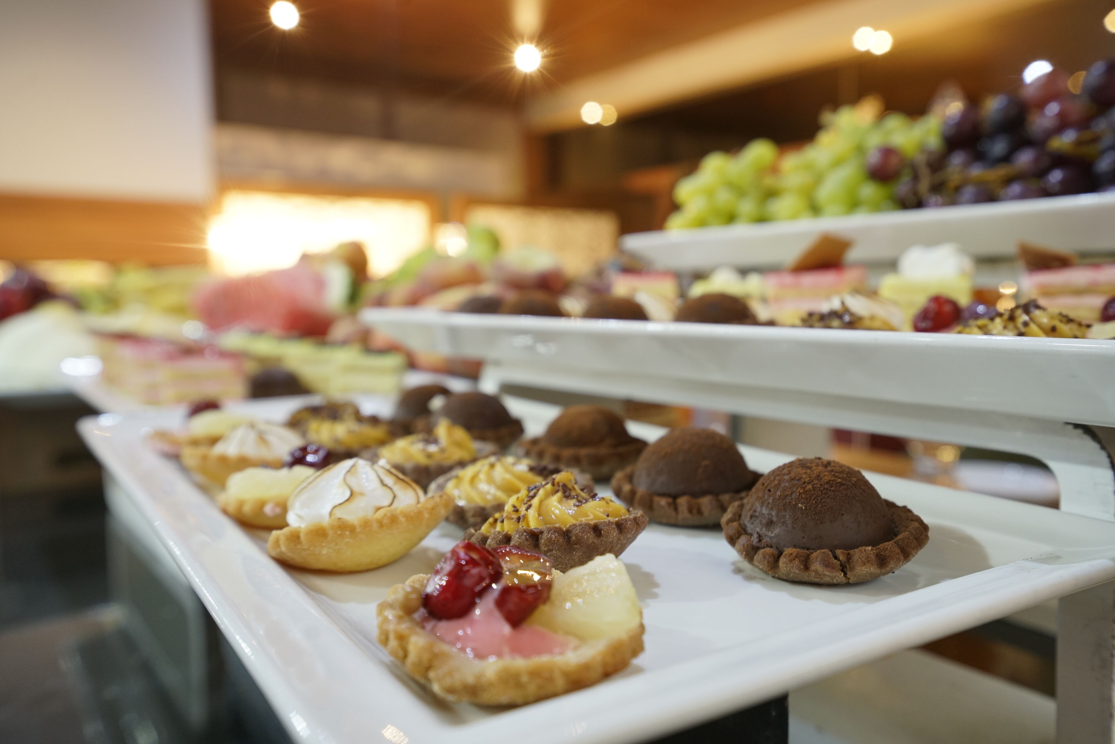 A buffet with various desserts and fruits.