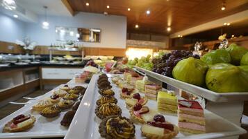 A buffet with various desserts and fruits.
