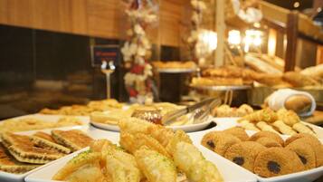 Un buffet proposant une variété de viennoiseries et de desserts.