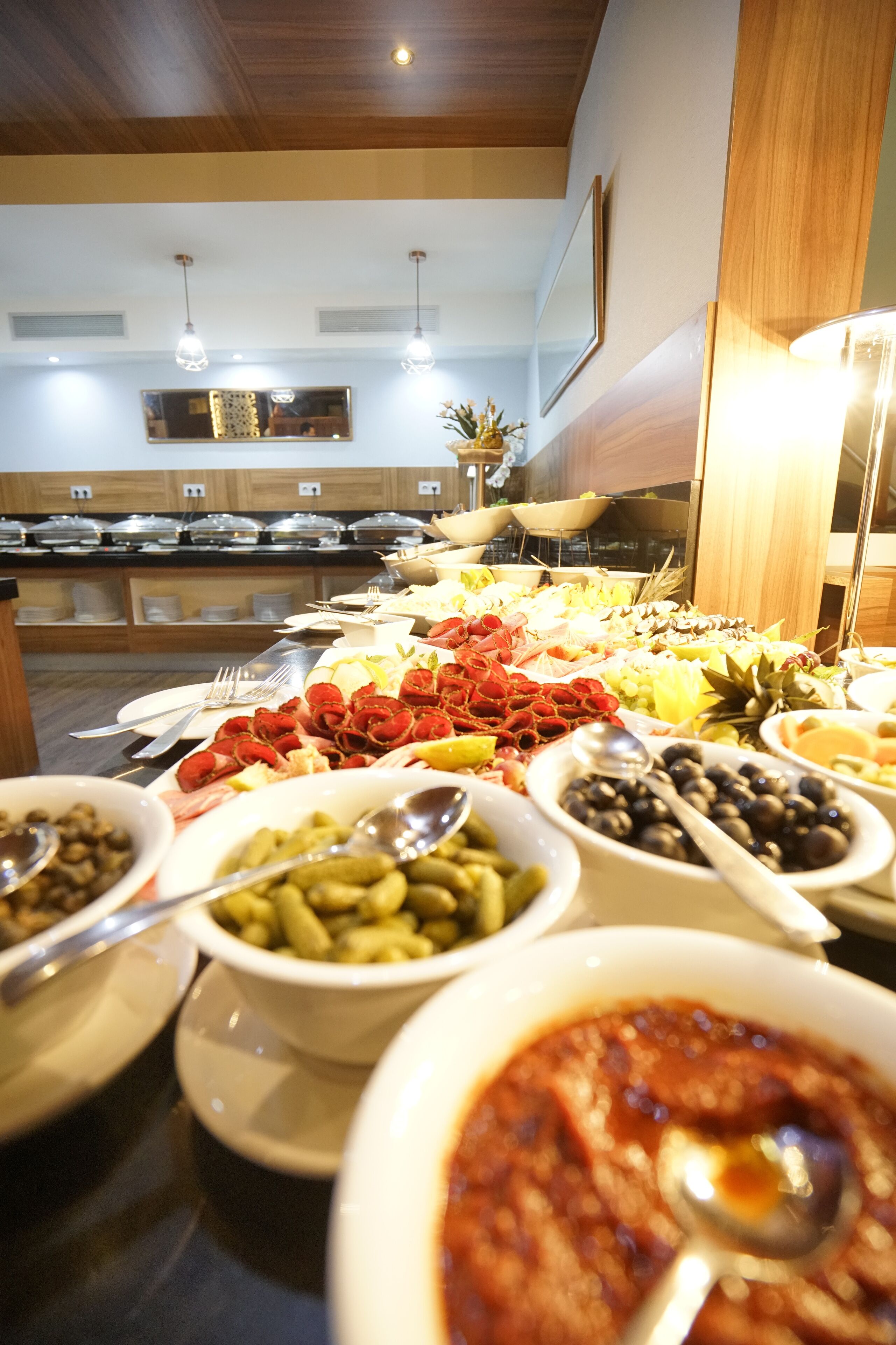A buffet with various food items and utensils.