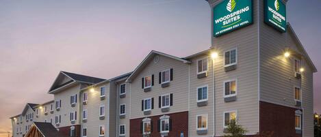 A multi-story hotel with a prominent signage for 'Woodspring Suites' indicating it is an extended stay hotel.