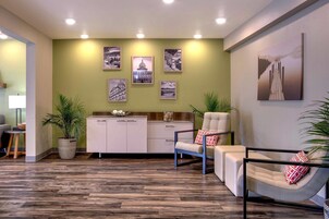 Un interior moderno con piso de madera, un gabinete blanco, un sofá y una silla.