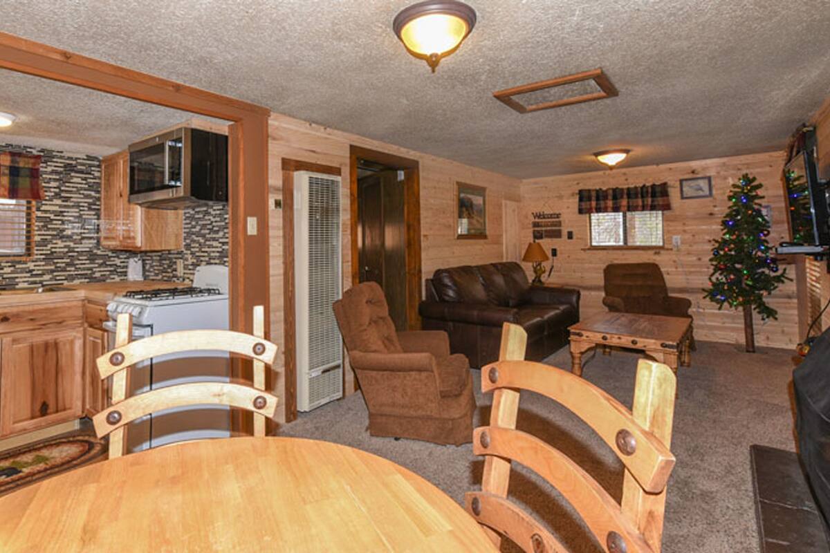 A cozy cabin interior with a kitchen, dining area, and living room.