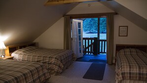 Une chambre confortable avec deux lits, un plafond en bois et une porte donnant sur une terrasse extérieure.