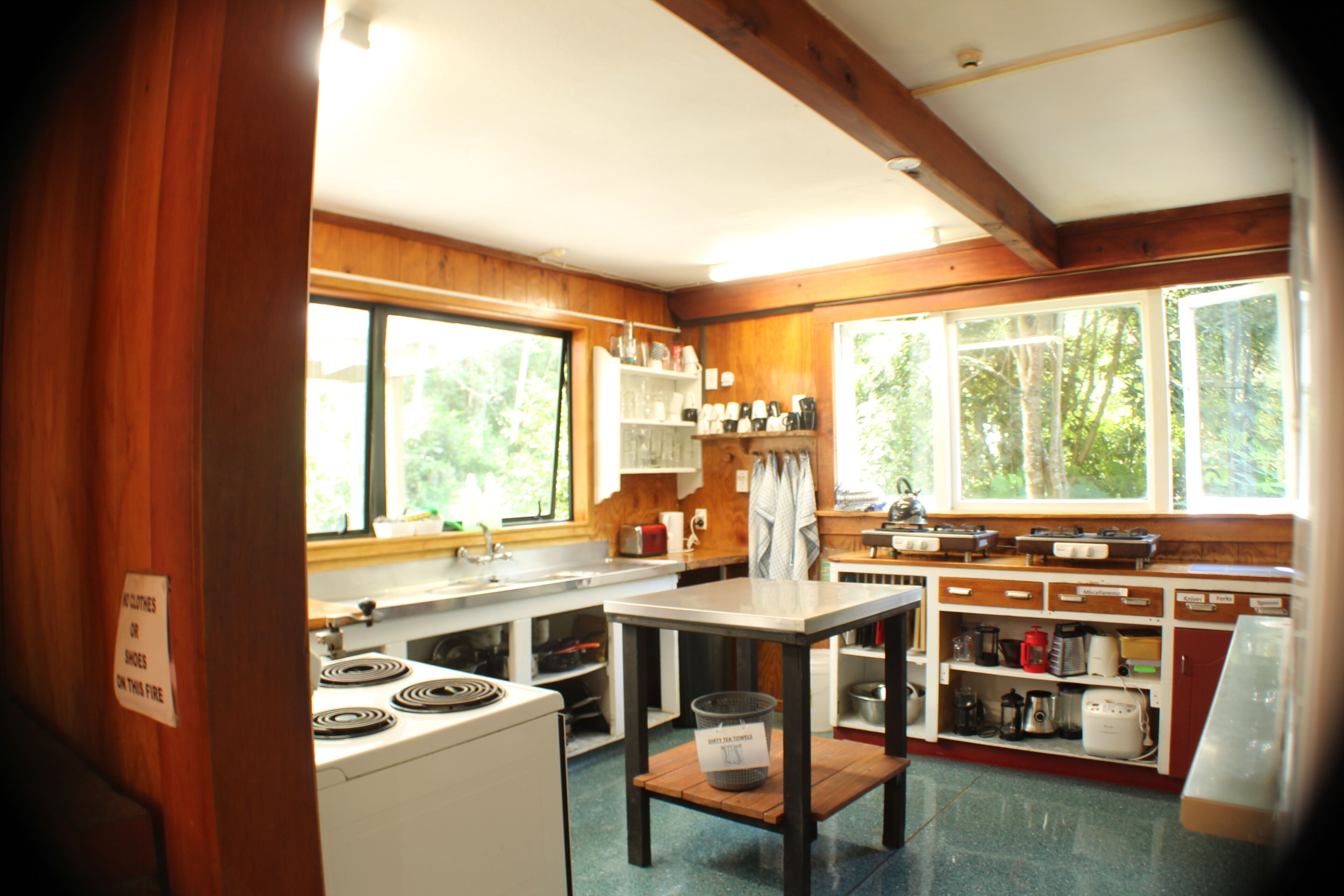 Una cocina con armarios de madera, una estufa y un lavamanos.
