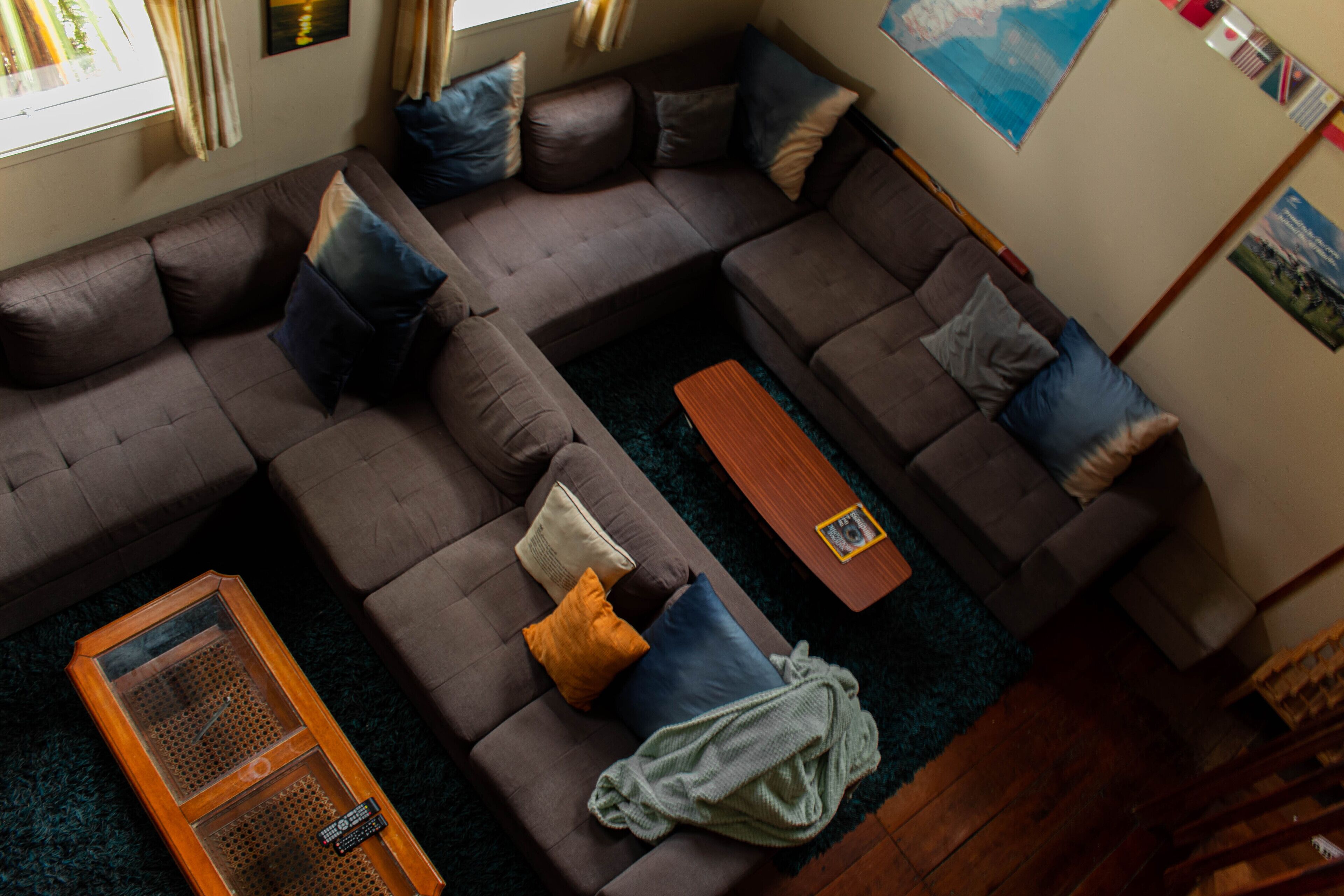 Una sala moderna con un sofá modular, una mesa de centro de madera y una mesa de centro de vidrio.