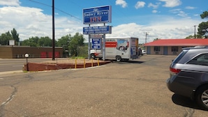 A Snowy River Inn sign with amenities like HBO, fax, phone, internet, low communication rates, AAP, coffee, and a microwave.