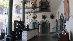 A lobby with a reception desk, a staircase, and decorative wall elements.