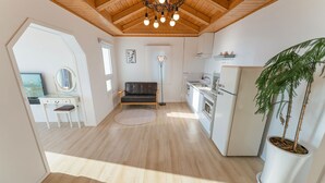 A compact living space with a kitchen, a dining area, and a seating area. - Bluegrad Pension (Namhae)