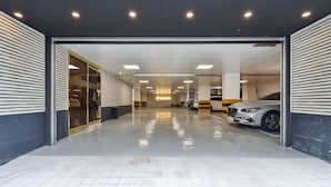 A modern indoor parking garage with a clean, tiled floor and a well-lit ceiling. - Grandis Hotel (Busan)