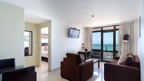 Ein modernes Hotelzimmer mit Balkon, Fernseher und Sitzecke.