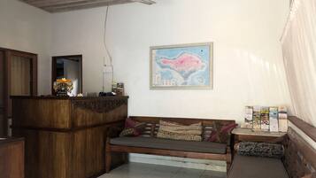 A reception area with a wooden desk, a sofa, and a wall-mounted map.