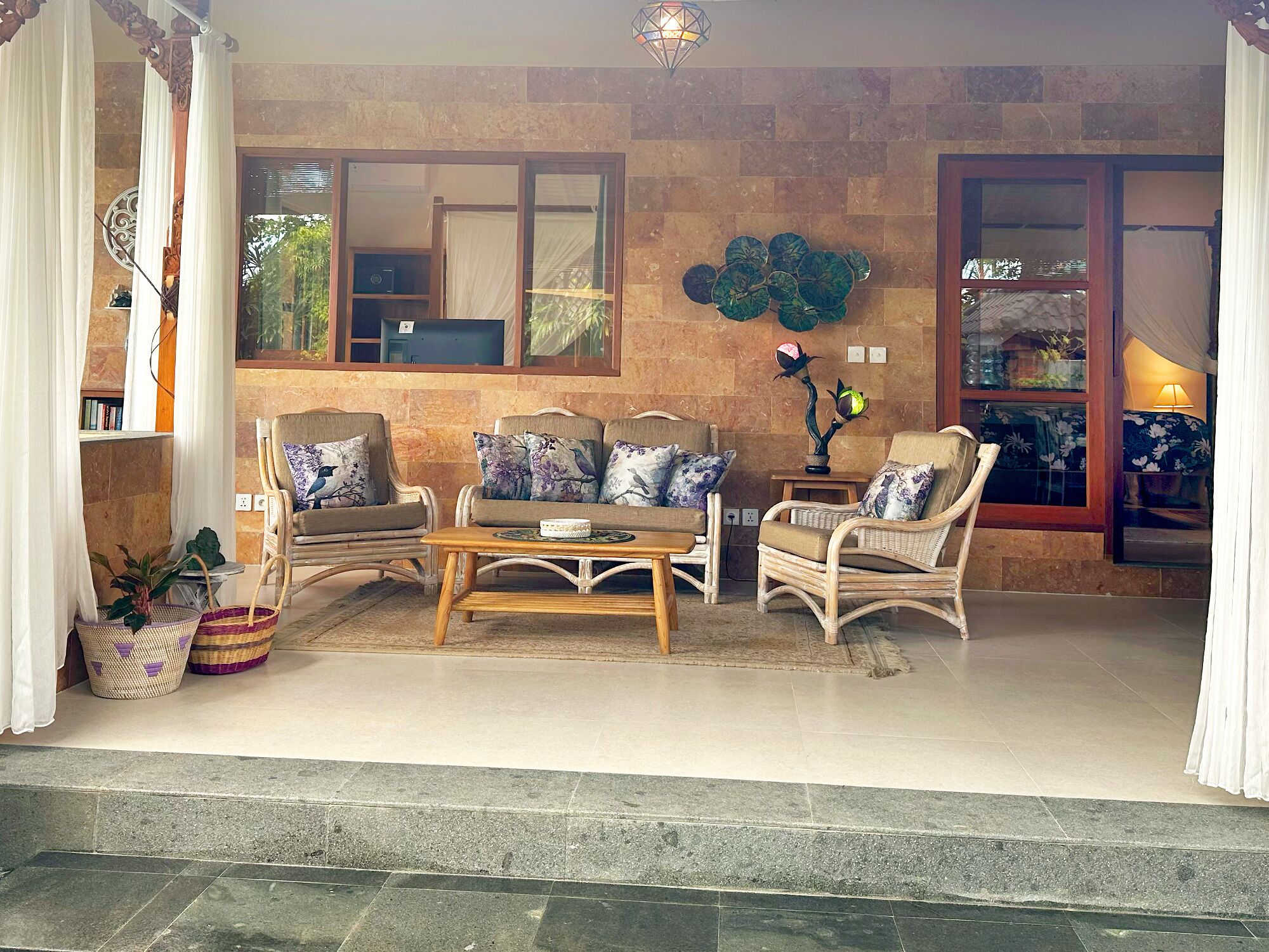A cozy living area with wicker furniture, a coffee table, and decorative pillows.