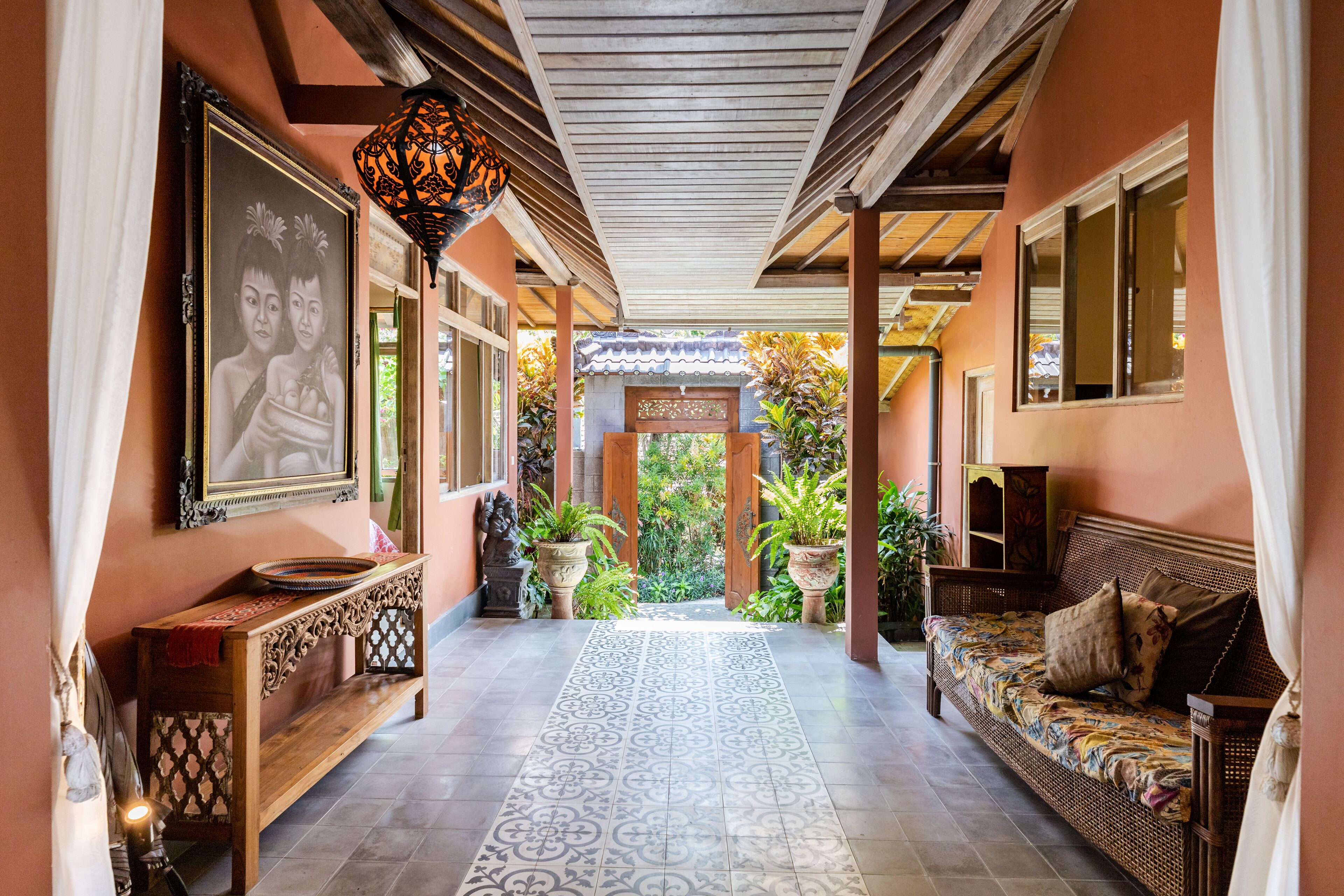 A corridor with a bench, a sofa, and a decorative lantern.