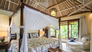 A four-poster bed with a canopy, a wicker sofa, and a large window with curtains. - Devi's Place (Ubud)