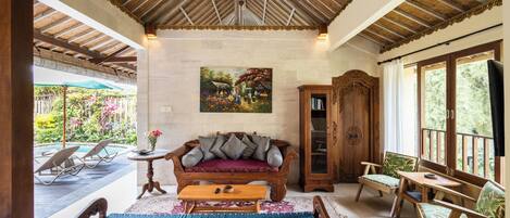 A cozy lounge area with a wooden bench, cushioned seating, and a ceiling fan.