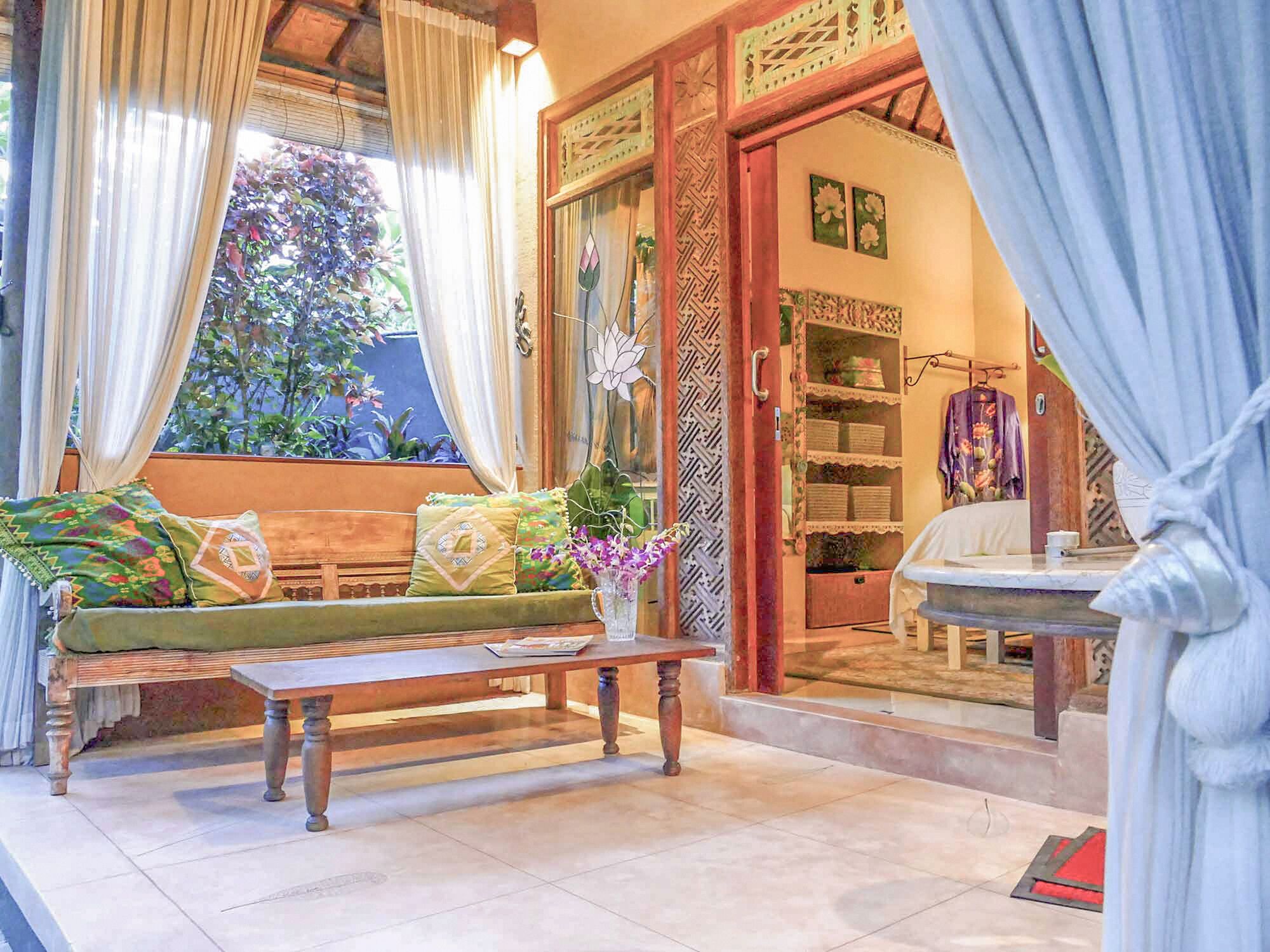 A room with a wooden bench, a table, and a window with curtains.
