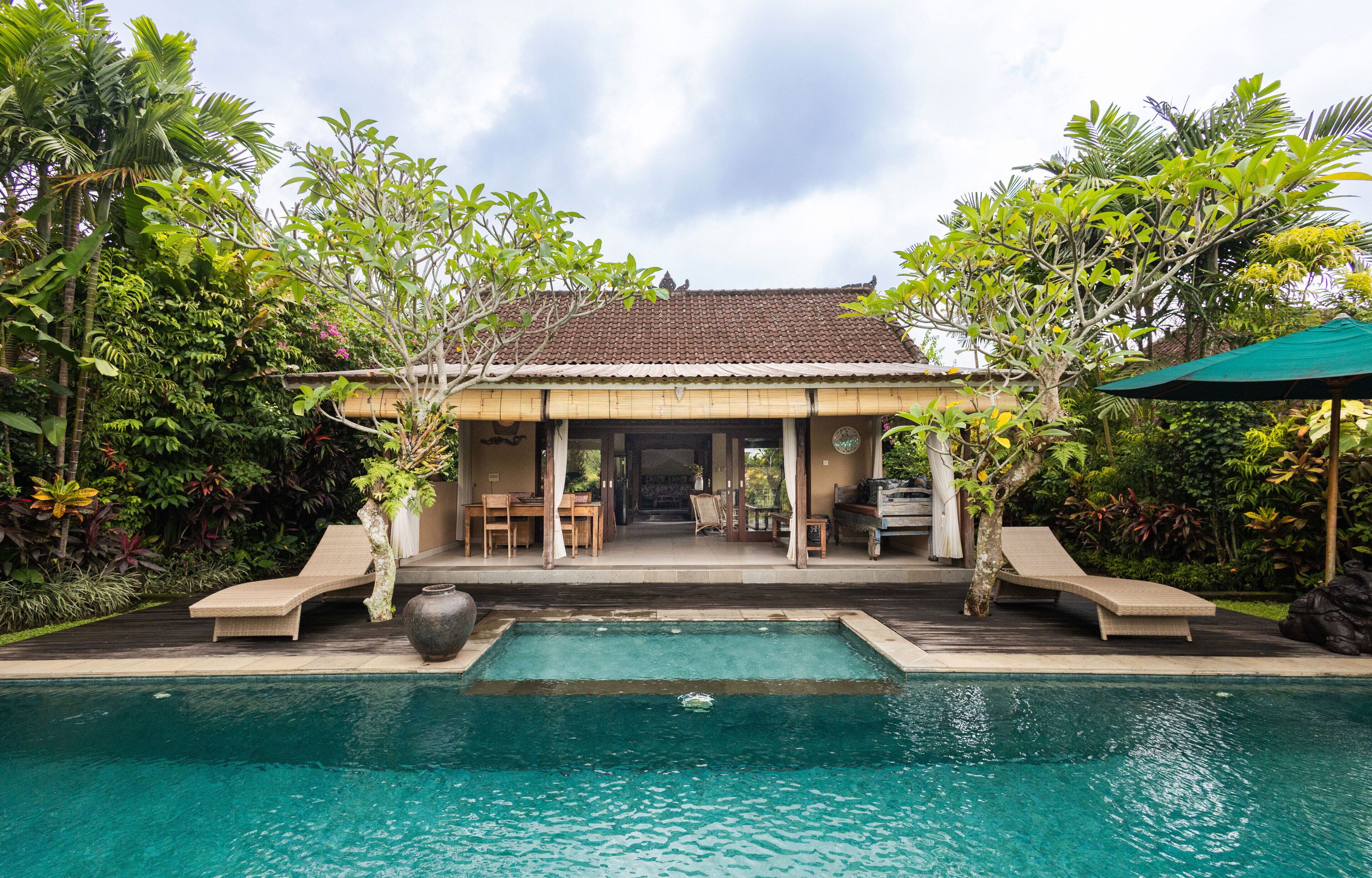 Eine Poolvilla mit Ziegeldach und einer überdachten Terrasse.