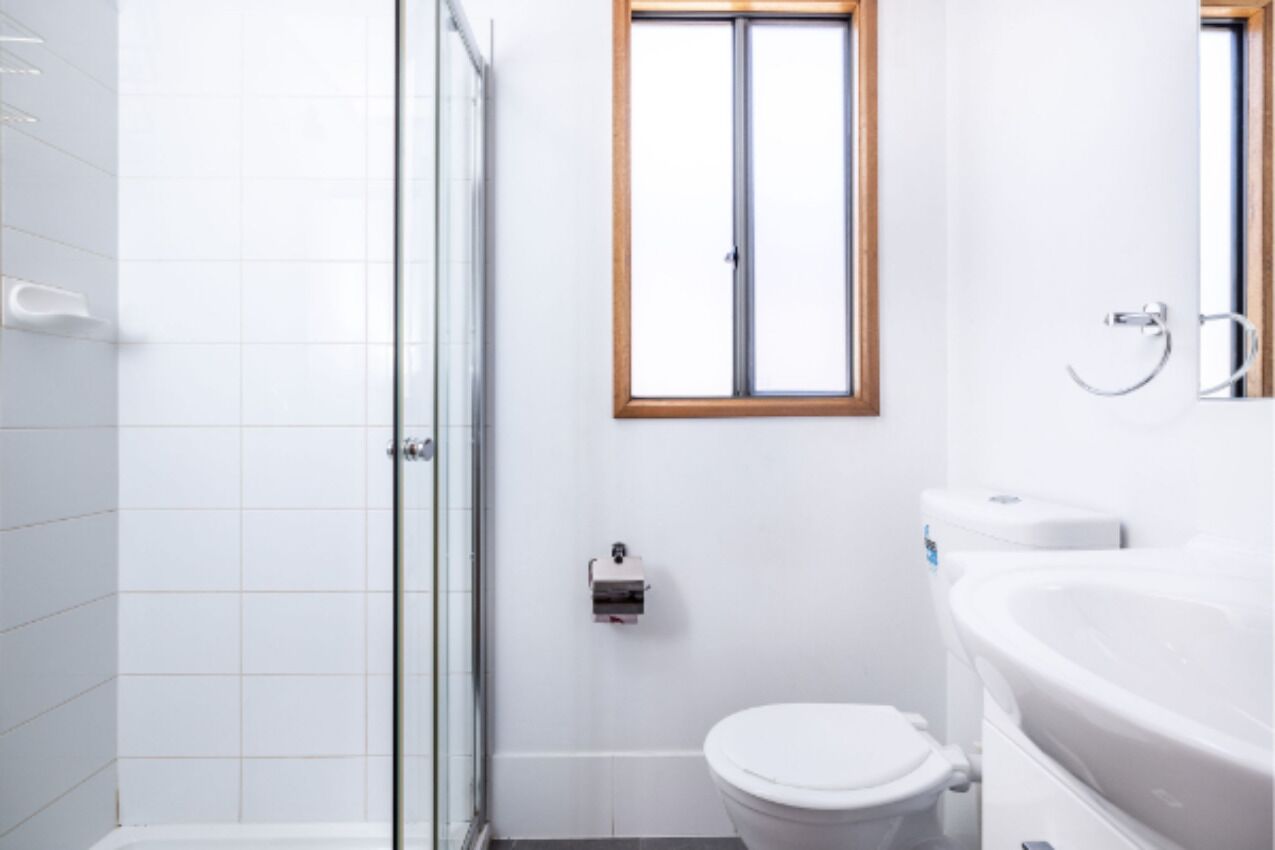 A bathroom with a toilet, a sink, and a shower.
