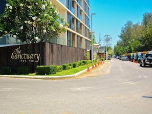 A modern building with a sign reading "The Sanctuary Hua Hin."