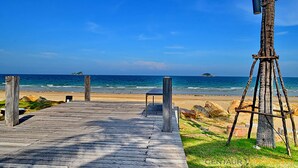 A wooden pier leading to a beach with a clear view of the ocean and distant islands. - Malibu Hua Hin by Puppap (Hua Hin)