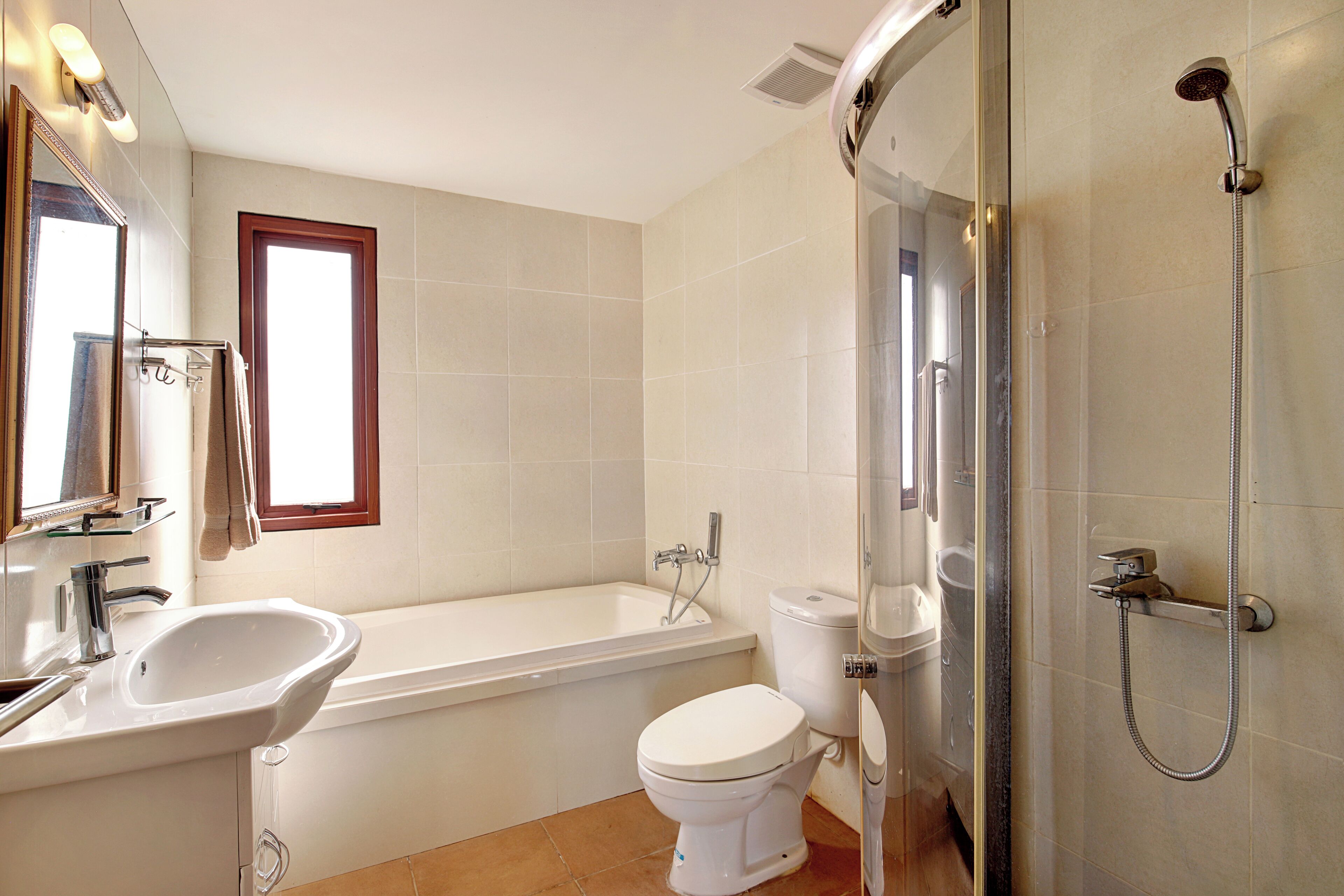 Une salle de bain moderne équipée d’une baignoire, de toilettes et d’une douche.