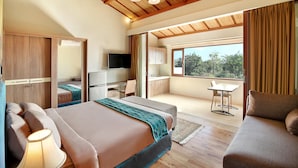 A bedroom with a bed, bedside table, and a TV. There is a balcony with a table and chairs. - Puri Sabina Bed & Breakfast (Jimbaran)
