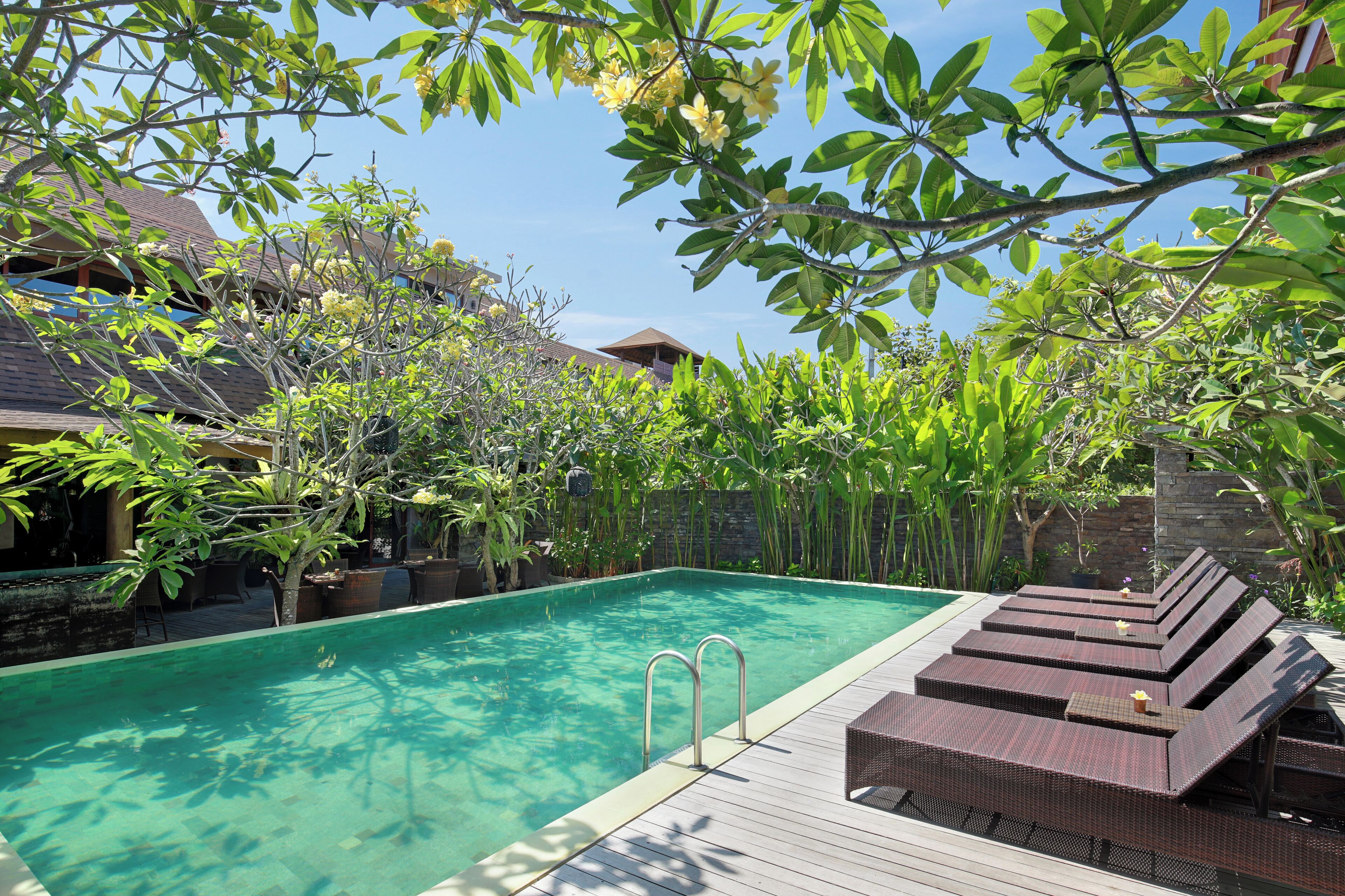 A swimming pool with lounge chairs and a wooden deck.