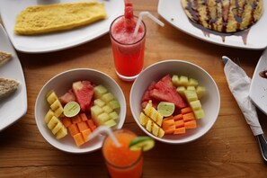 A table with fruit bowls, a smoothie, and a plate of food. - Dewi Sri Private Villa (Ubud)