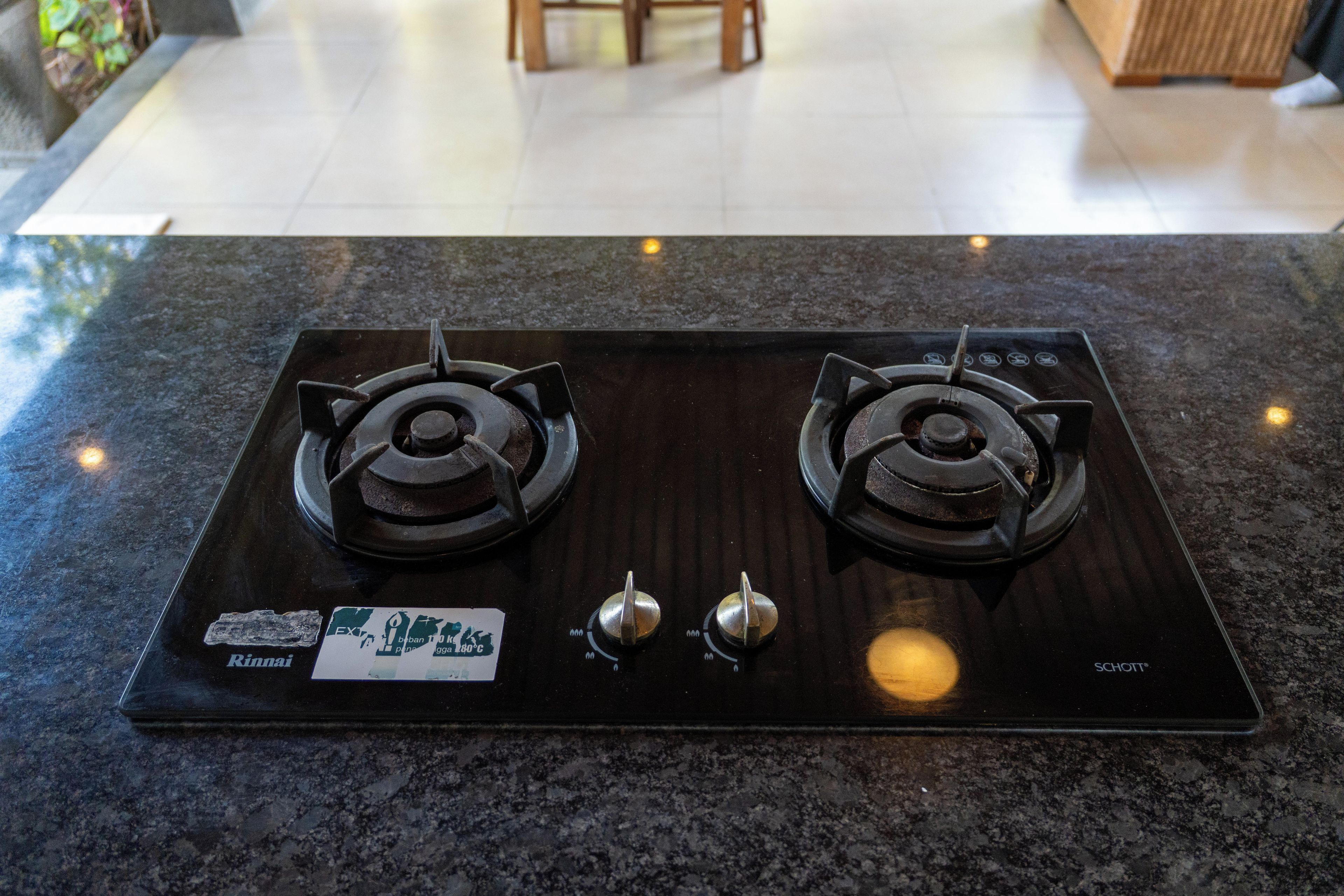 A kitchen with a black stove top, two burners, and a control panel.