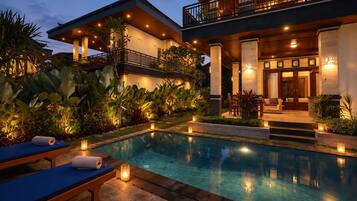 A poolside area with a lounge chair, a small table, and a bench.