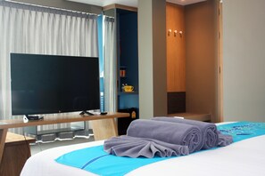Una habitación de hotel con cama, televisión, escritorio y armario.