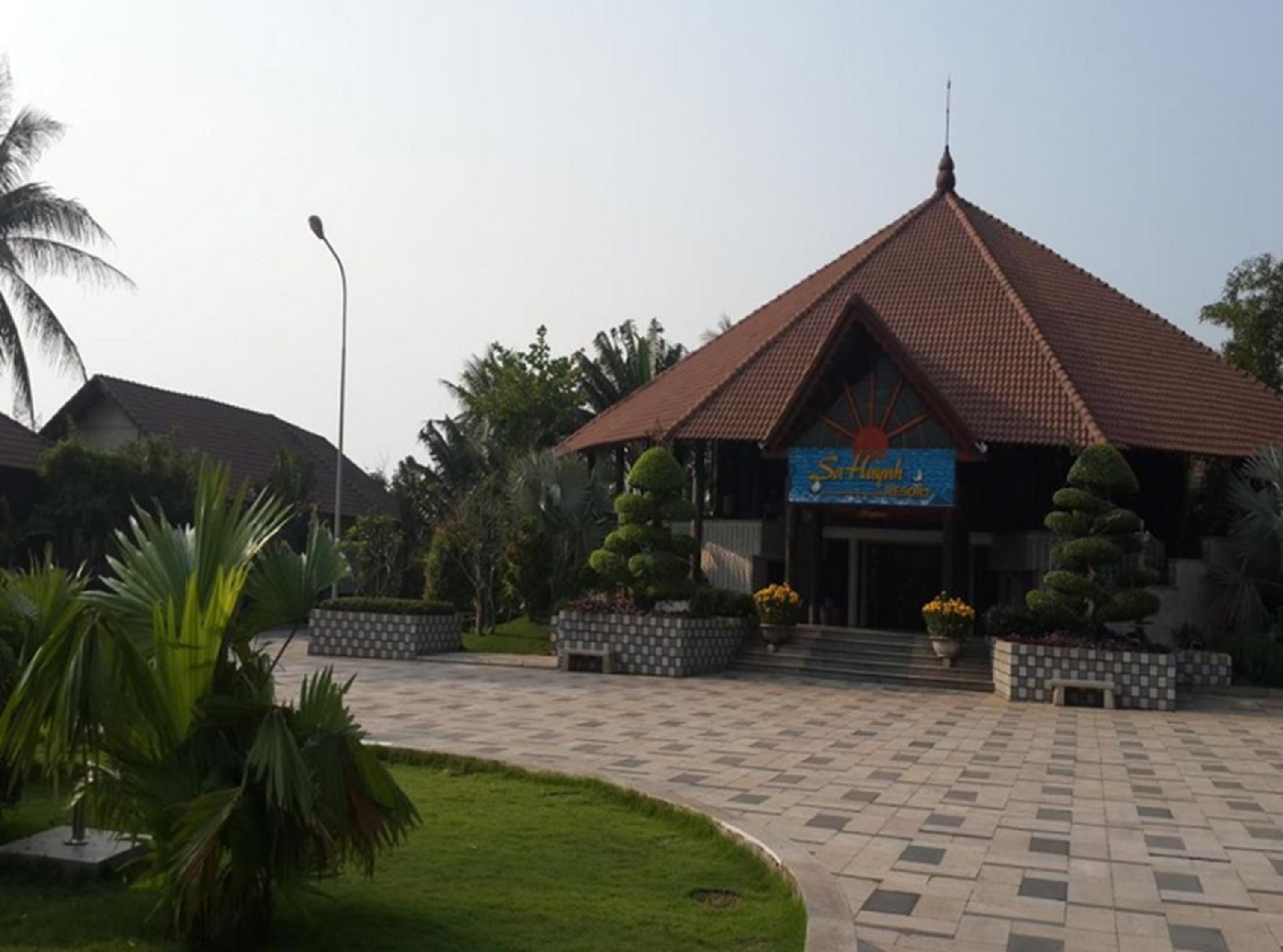 A resort with a tiled entrance and a signboard.