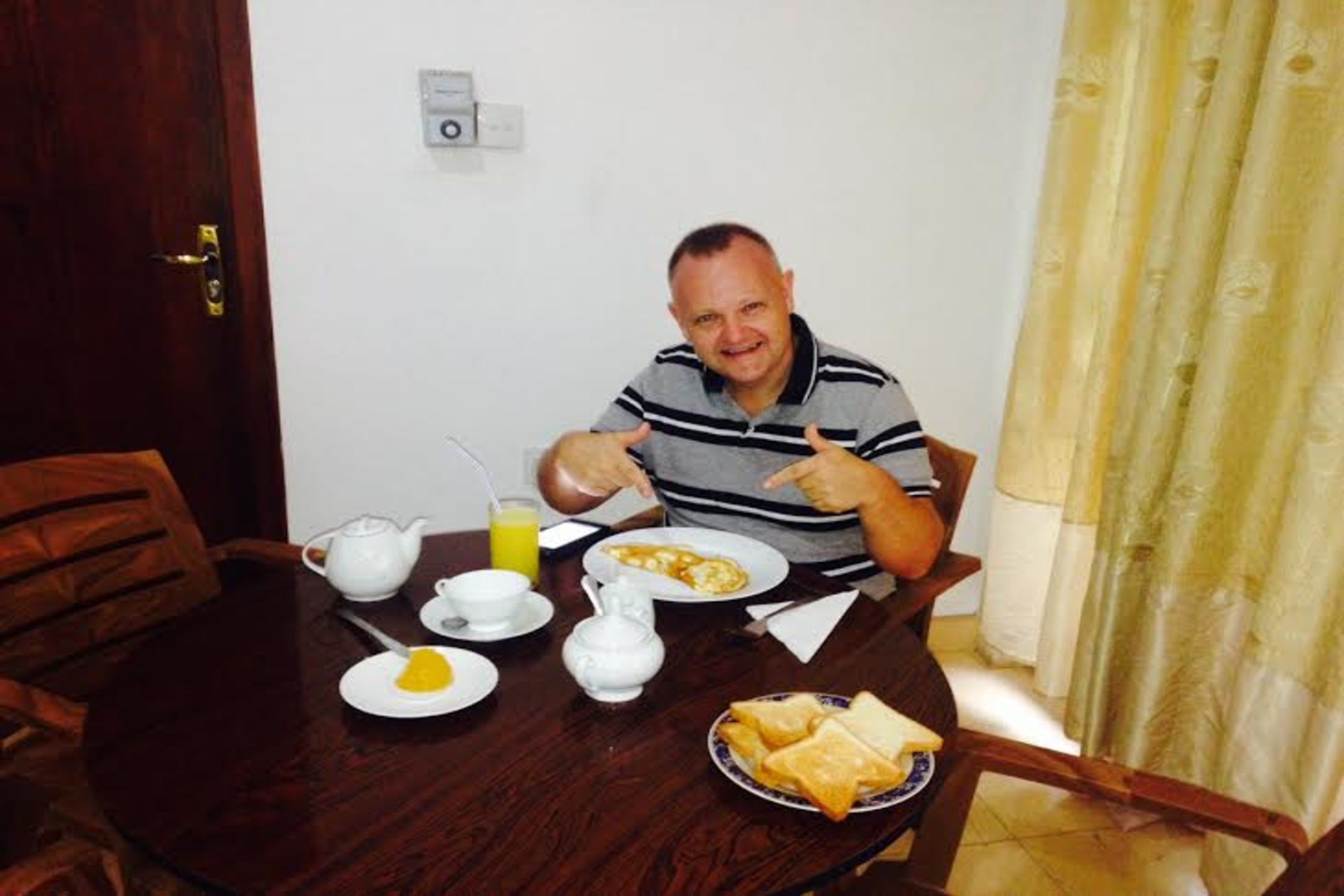 A dining table with breakfast items including toast, eggs, and a jug of orange juice.