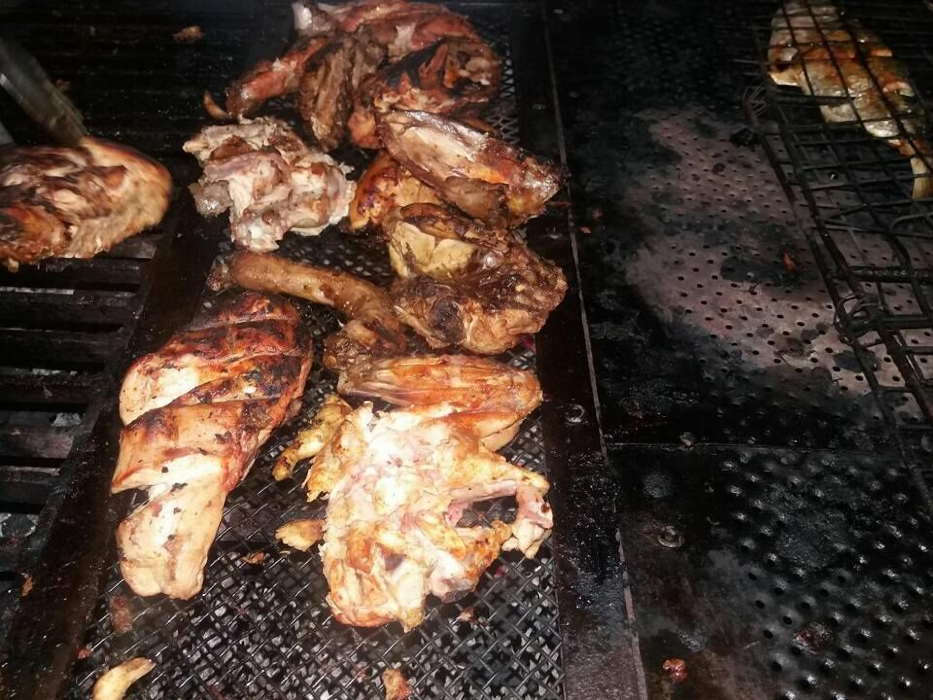 A grill with various meats being cooked.