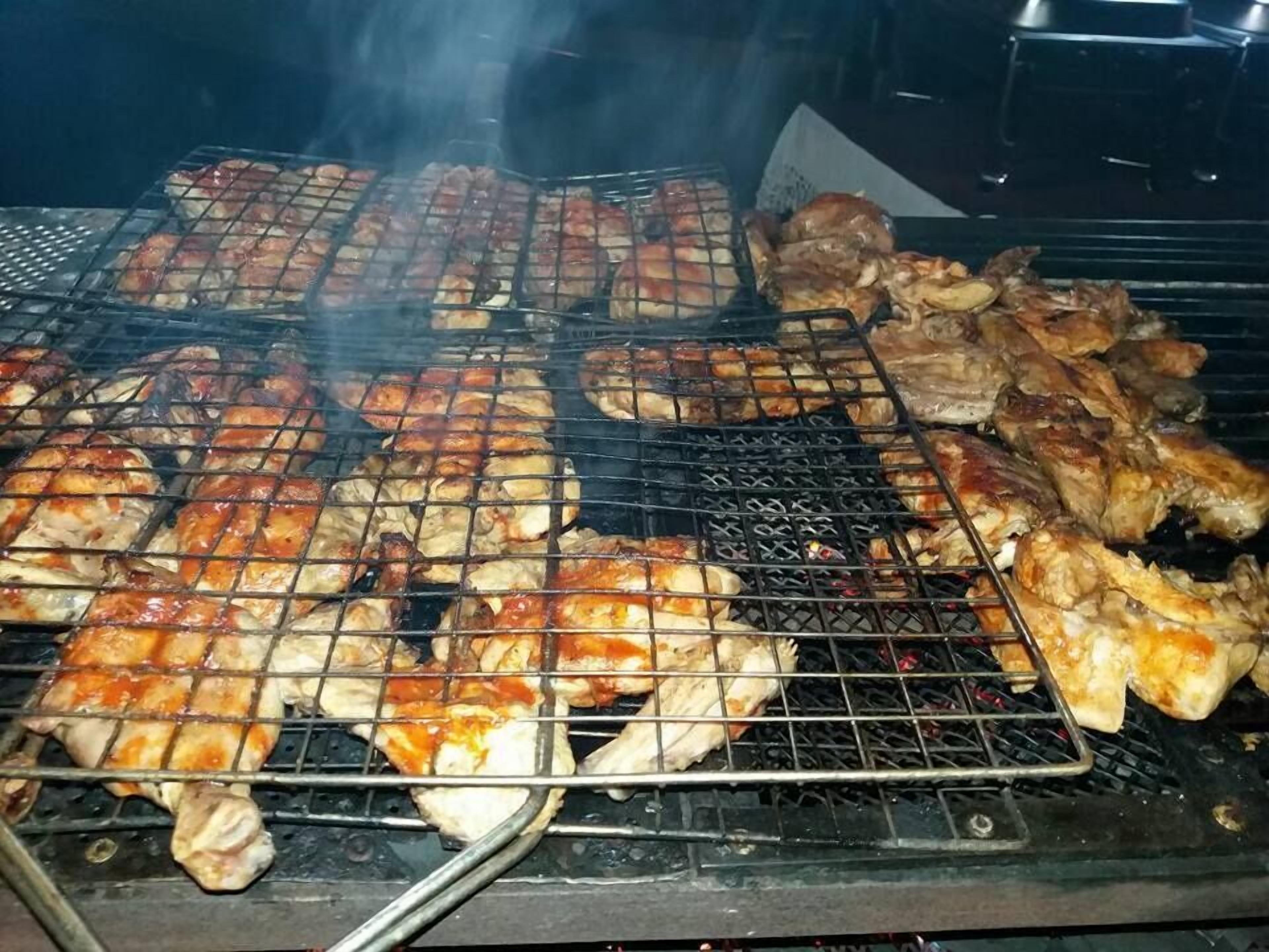 A grill with various meats being cooked.