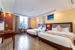 Een hotelkamer met twee bedden, een bureau, een stoel en een raam met uitzicht.