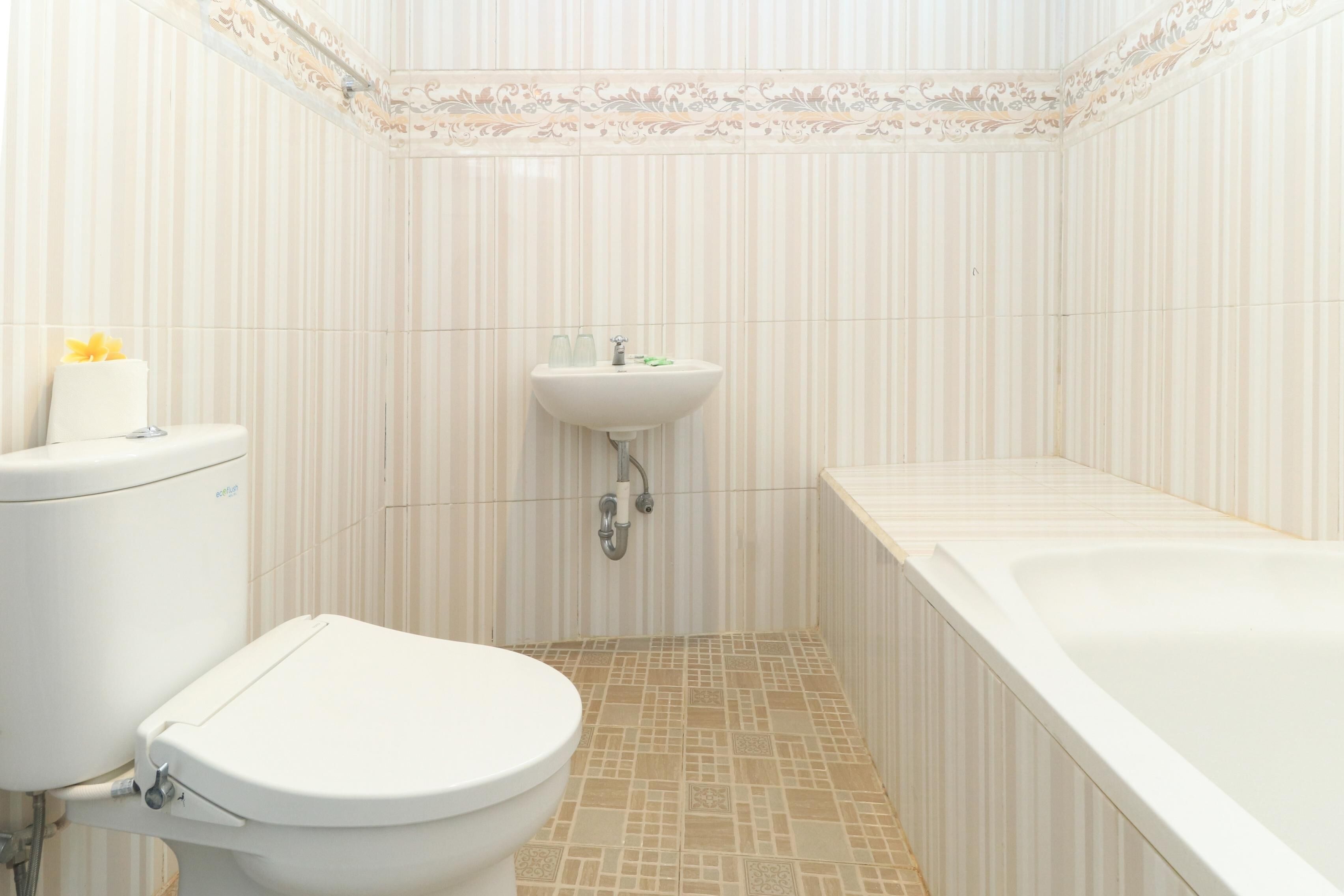 Een badkamer met toilet, wastafel en bad.