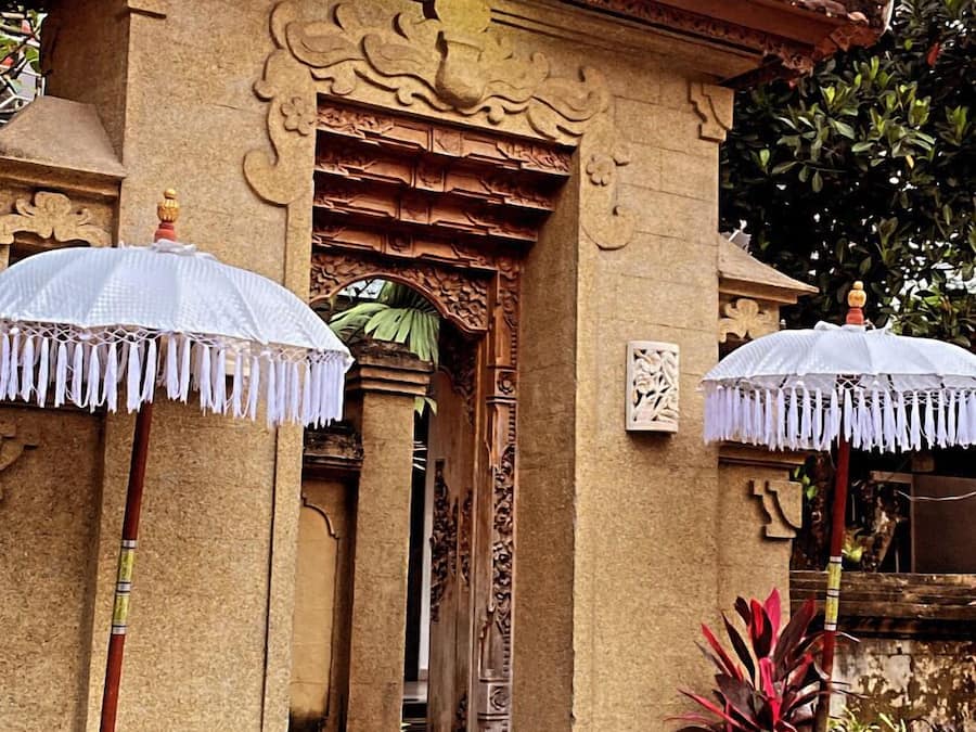 A traditional building with ornate carvings, a tiled roof, and a small entrance with steps leading up to it.