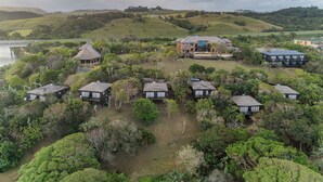 A residential area with multiple houses surrounded by lush greenery and hills in the background. - Sugar Beach Resort (Elysium)