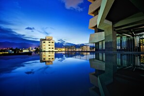 A modern building with a reflective pool in the foreground, a clear sky, and distant mountains. - The Suites Taitung (Taitung)