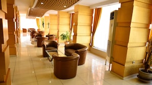 A hotel lobby with a modern design, featuring leather sofas, a glass coffee table, and potted plants. - Kıvrak Hotel (Antalya)